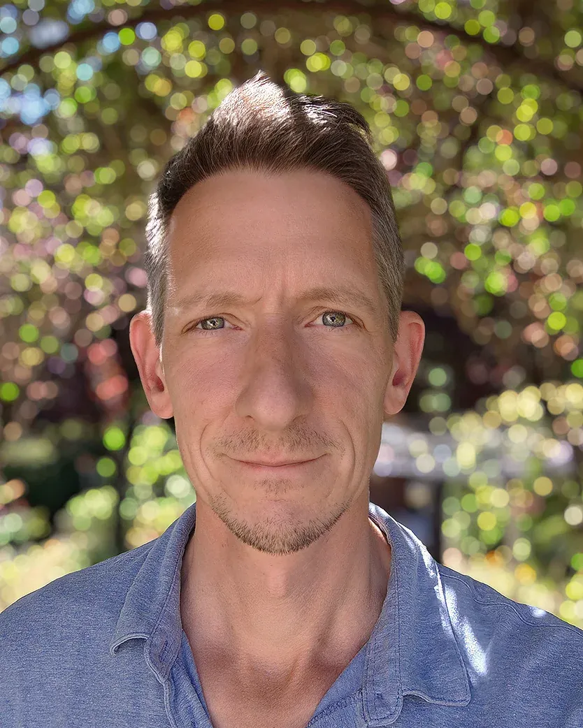 Philippe Ramakers, Porträt im Freien vor unscharfem Laub